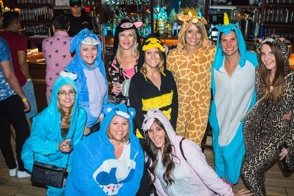 Friends in animal onesies enjoying drinks on the crawl